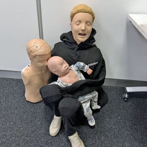 Learner holding infant and child CPR manikins